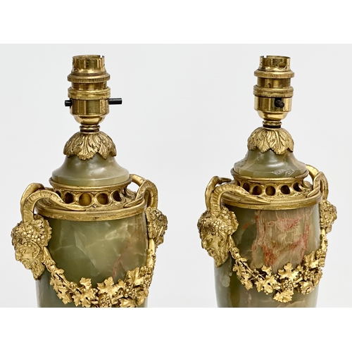 18 - A pair of excellent quality early 20th century gilt brass and onyx table lamps with rams head masks,... 