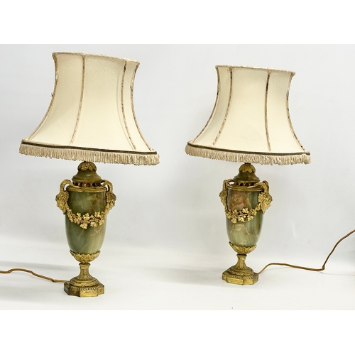 18 - A pair of excellent quality early 20th century gilt brass and onyx table lamps with rams head masks,... 