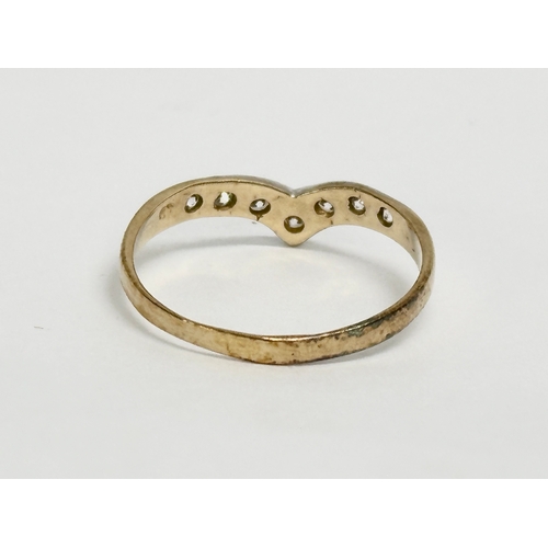 506 - A vintage 9ct gold and diamond wish bone ring with case. Size O. 1.25 grams.