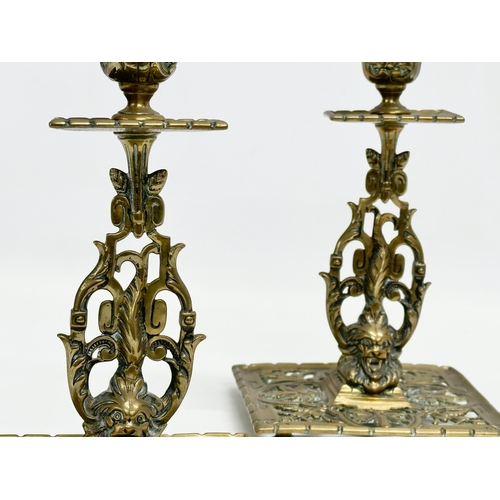 60G - A pair of Victorian pierced brass candlesticks with lion mask design and butterfly motif. 12x12x21cm