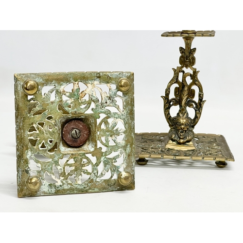 60G - A pair of Victorian pierced brass candlesticks with lion mask design and butterfly motif. 12x12x21cm