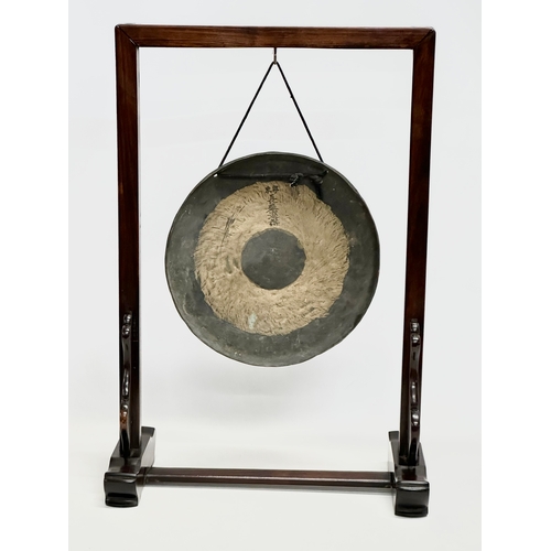 153F - A late 19th/early 20th century Chinese brass gong in a later rosewood frame. 46x21x68cm