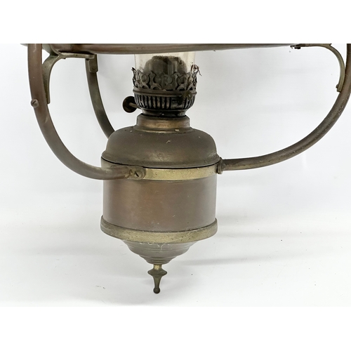 275G - An early 20th century hanging brass oil lamp with glass shade. 37x75cm