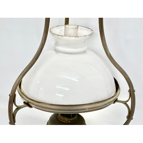 275G - An early 20th century hanging brass oil lamp with glass shade. 37x75cm