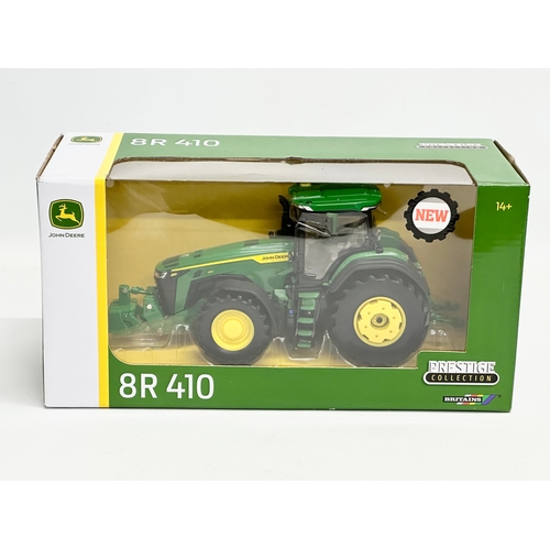 719 - A new Britains Prestige Collection John Deere 8R 410 tractor in box. 30x13x15cm