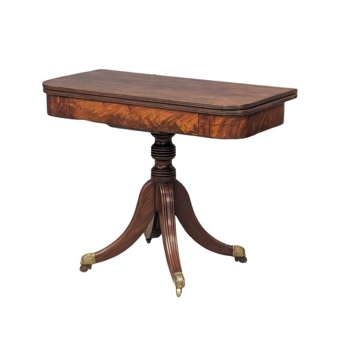 1133 - A late George III mahogany games table, with reeded column pedestal and brass feet with acranthus le... 