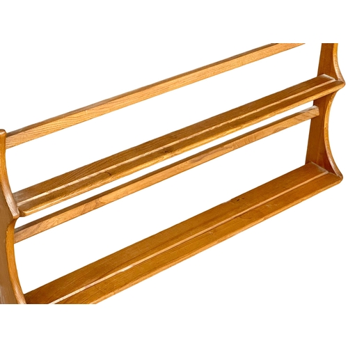 218 - An Ercol Mid Century Elm wall hanging plate rack. 96.5cm