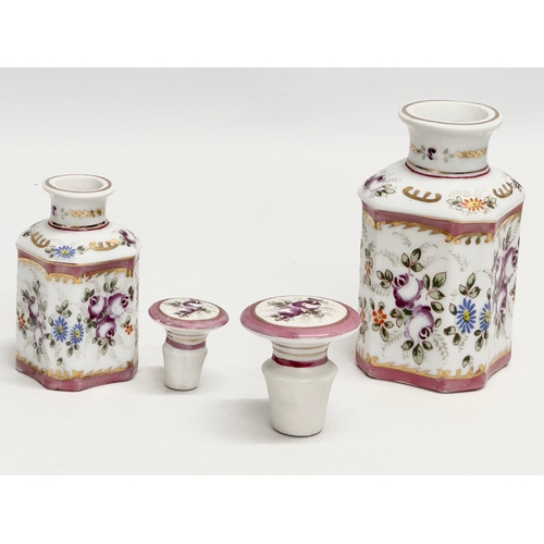 69 - A pair of late 19th century French hand painted porcelain vanity jars/perfume bottles. Largest 14cm.... 