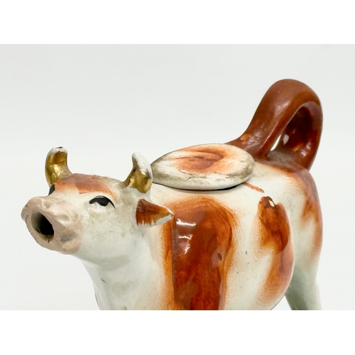 21 - A mid 19th century Victorian Staffordshire pottery Cow Creamer. 16.5x10.5cm