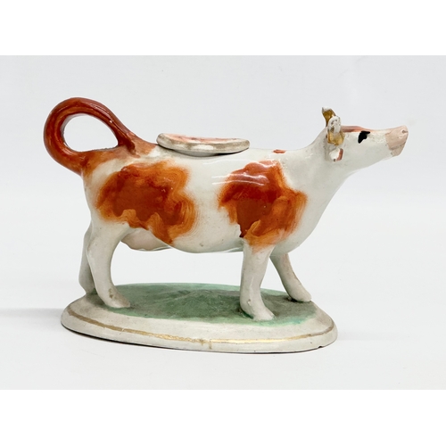 21 - A mid 19th century Victorian Staffordshire pottery Cow Creamer. 16.5x10.5cm