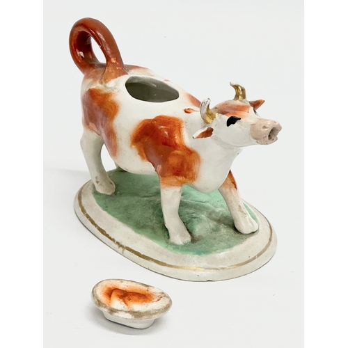 21 - A mid 19th century Victorian Staffordshire pottery Cow Creamer. 16.5x10.5cm