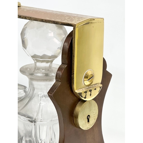 90 - A mahogany and brass tantalus with 3 matching crystal decanters. No key. 39x15x35cm