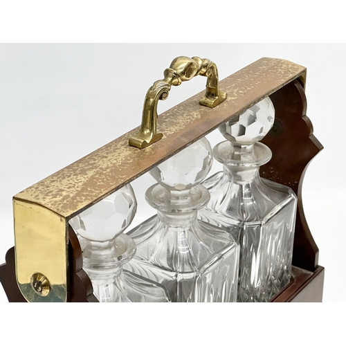 90 - A mahogany and brass tantalus with 3 matching crystal decanters. No key. 39x15x35cm