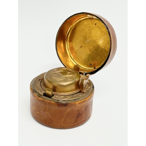 430 - A Victorian brass and leather bound travel inkwell. 5x4cm