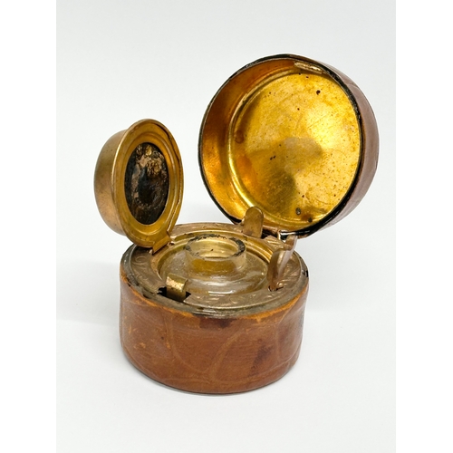 430 - A Victorian brass and leather bound travel inkwell. 5x4cm