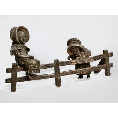 262 - A bronze ‘Two Little Girls Sitting’ figurine. 16x8cm