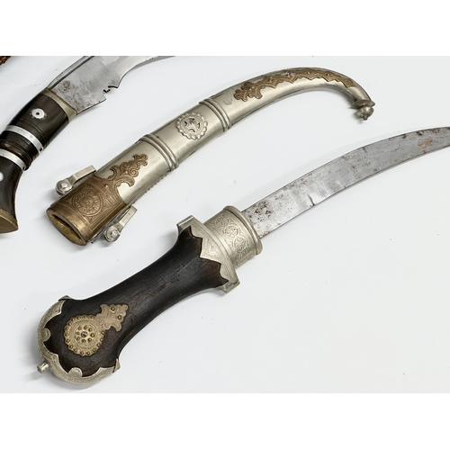 401 - A vintage steel bladed Kindjal dagger with wooden handle and scabbard. Together with a Gurkha style ... 