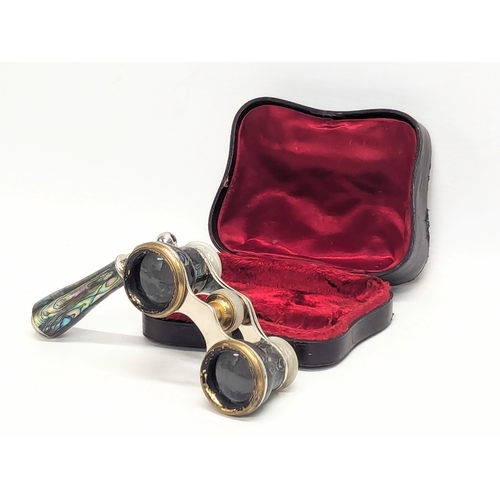 670 - A pair of vintage abalone opera glasses with extending handle in case.