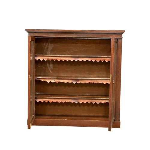 923 - A Victorian mahogany double door bookcase with adjustable shelves and original leather. 107x28x106.5... 