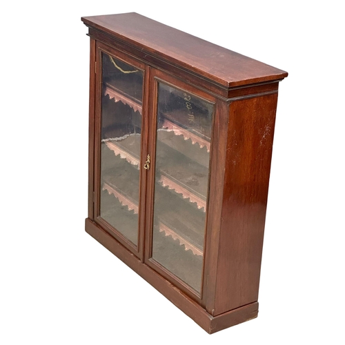 923 - A Victorian mahogany double door bookcase with adjustable shelves and original leather. 107x28x106.5... 