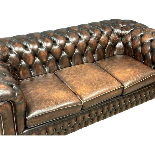 924 - A deep buttoned leather 3 seater sofa. 211cm