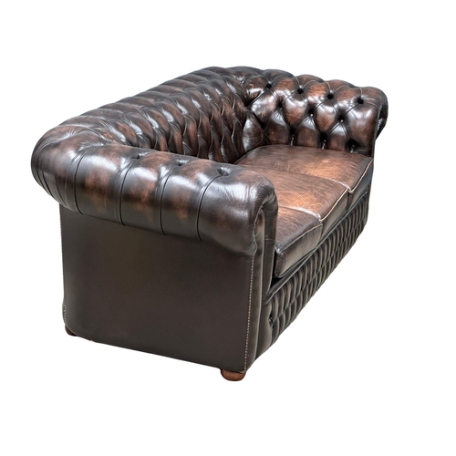 924 - A deep buttoned leather 3 seater sofa. 211cm