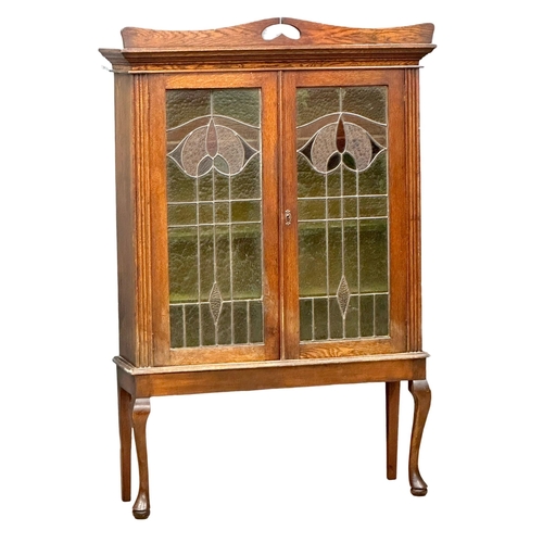 925 - An early 20th century Art Nouveau oak bookcase on stand with stained glass panel doors. Circa 1910-1... 