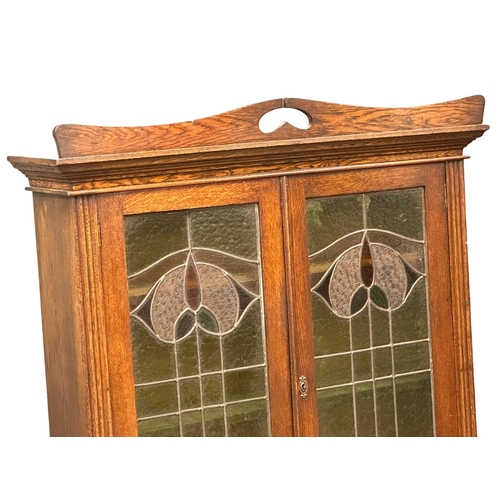 925 - An early 20th century Art Nouveau oak bookcase on stand with stained glass panel doors. Circa 1910-1... 