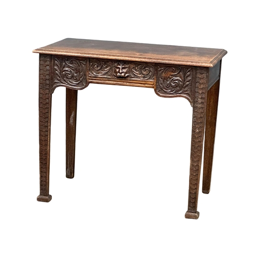 931 - A Victorian oak side table with carved wild flower motif and Man of the Forest drawer. Circa 1870. R... 