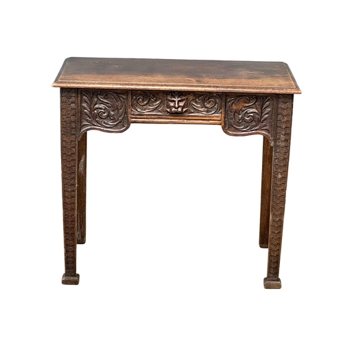 931 - A Victorian oak side table with carved wild flower motif and Man of the Forest drawer. Circa 1870. R... 