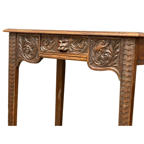 931 - A Victorian oak side table with carved wild flower motif and Man of the Forest drawer. Circa 1870. R... 