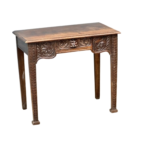 931 - A Victorian oak side table with carved wild flower motif and Man of the Forest drawer. Circa 1870. R... 