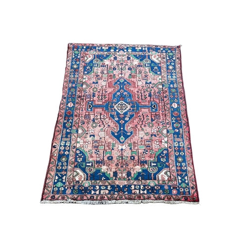 938 - A vintage Iranian Middle Eastern hand knotted rug. 137x213cm