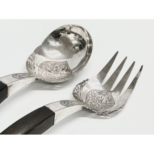 337 - Malaysian silver. A pair of late 19th/early 20th century Malaysian silver serving tools with horn ha... 