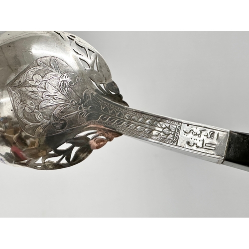 337 - Malaysian silver. A pair of late 19th/early 20th century Malaysian silver serving tools with horn ha... 