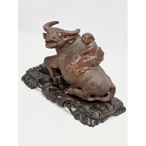 317 - A pair of early 20th century Chinese carved Water Buffalo’s with riders on stands. 26x12x16cm