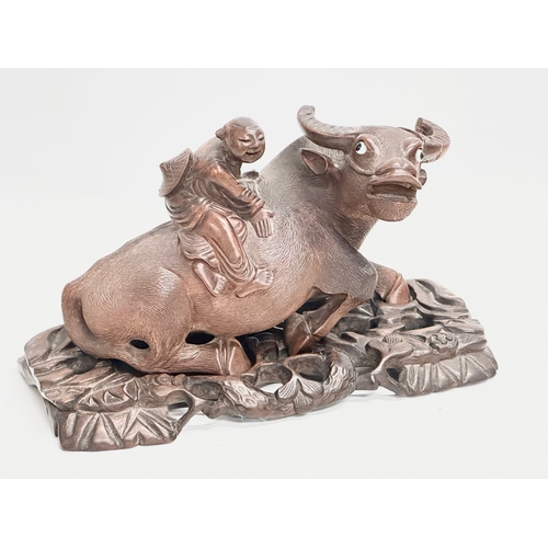 317 - A pair of early 20th century Chinese carved Water Buffalo’s with riders on stands. 26x12x16cm