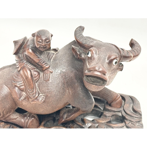 317 - A pair of early 20th century Chinese carved Water Buffalo’s with riders on stands. 26x12x16cm