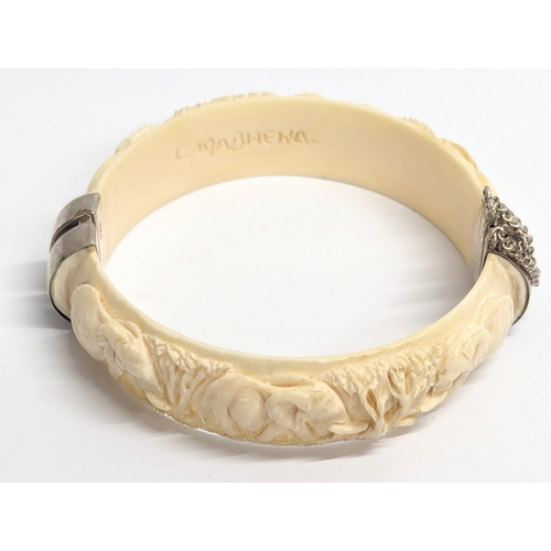 643 - A decorative bangle with silver clasps