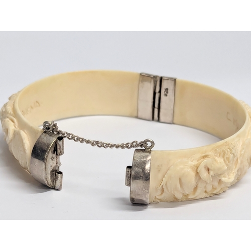 643 - A decorative bangle with silver clasps