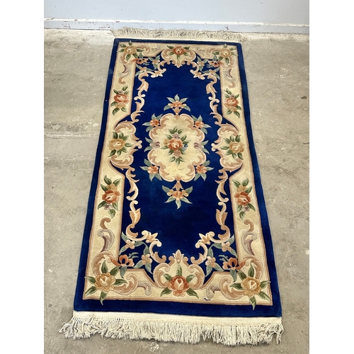 57 - A wool rug. 91x209cm