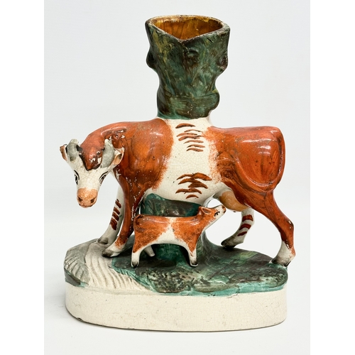 8 - A pair of mid/late 19th century Staffordshire Cow spill vases. 22x27.5cm