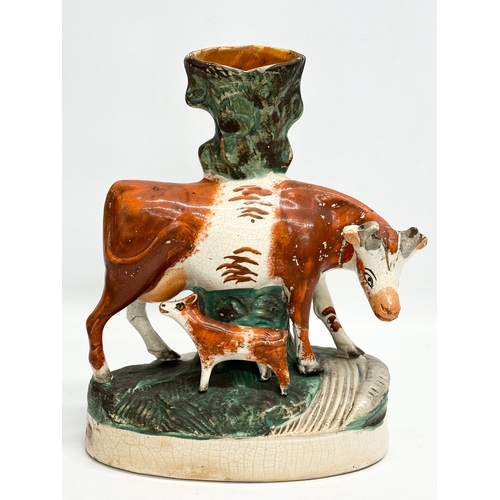 8 - A pair of mid/late 19th century Staffordshire Cow spill vases. 22x27.5cm