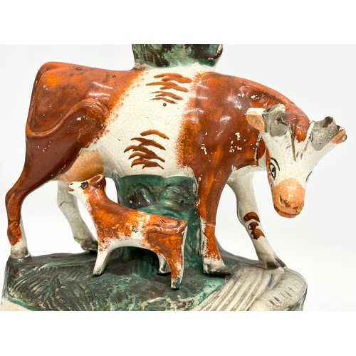 8 - A pair of mid/late 19th century Staffordshire Cow spill vases. 22x27.5cm