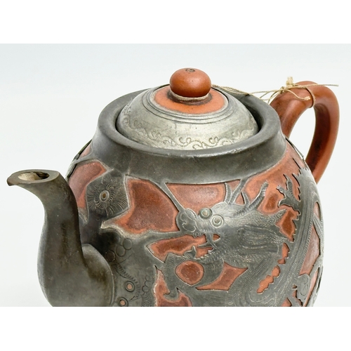 170 - A Chinese “Sunshine Chang” pewter bound terracotta teapot, with dragon design. 20x14cm