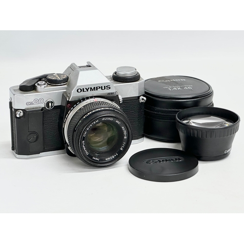 543 - A vintage Olympus OM20 camera and a Canon lens with case.