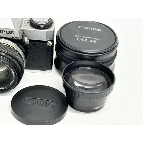 543 - A vintage Olympus OM20 camera and a Canon lens with case.