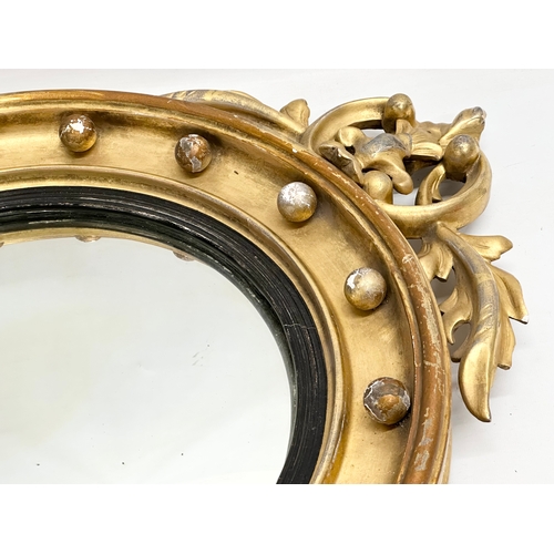 805A - An early 19th century Regency period gilt framed convex mirror with an early 20th century back. Circ... 