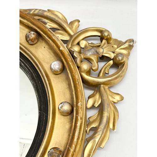 805A - An early 19th century Regency period gilt framed convex mirror with an early 20th century back. Circ... 