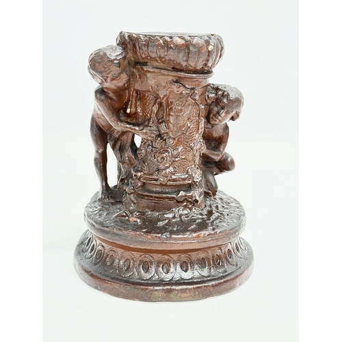 97 - A 19th Century glazed ceramic cherub candleholder. 13x15cm